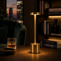 Decorus Designs Ambient Desk Lamp in brushed gold on a marble surface with warm ambient glow