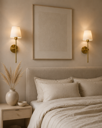 Gold wall sconce pair above bed in luxury minimalist bedroom