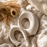 White ceramic arch vase close up with dried stem minimalist home decor
